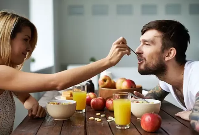 žena krmí muže ořechy, aby zvýšila potenciál